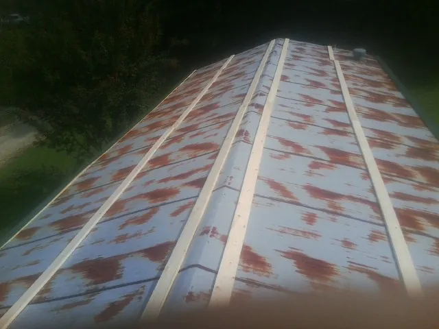 Rusted metal roof panels with new wood purlins before replacement — Storm Damage Roof Repair in Graham by Roofing Brothers