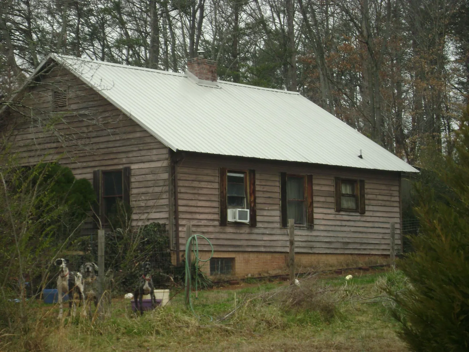 White metal roof on an old wood sided farmhouse, from a Metal Roof Installation job in Graham